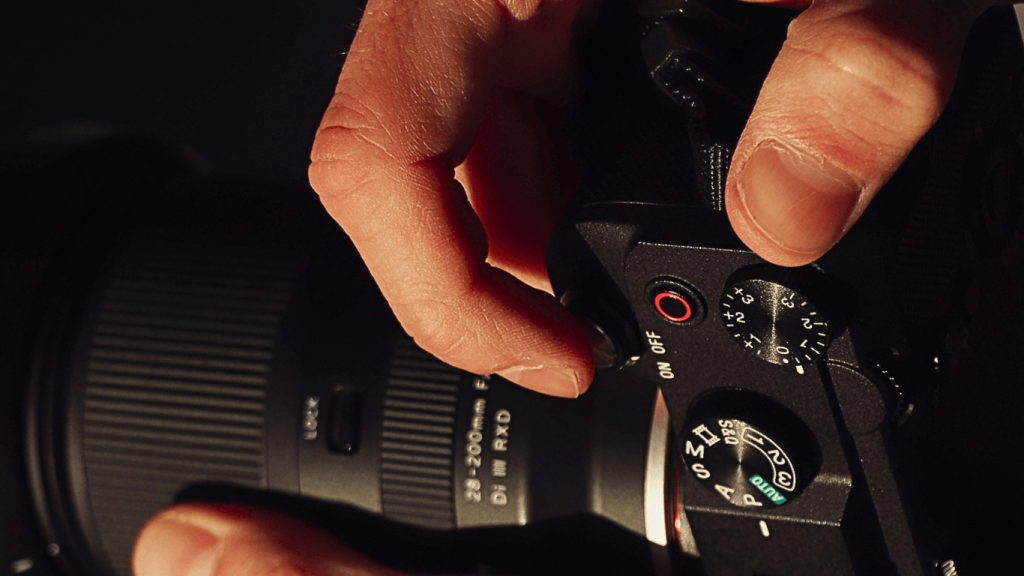 Gambar tangan sedang menggunakan sony a7iv, merupakan salah satu kamera mirrorless terbaik 2026