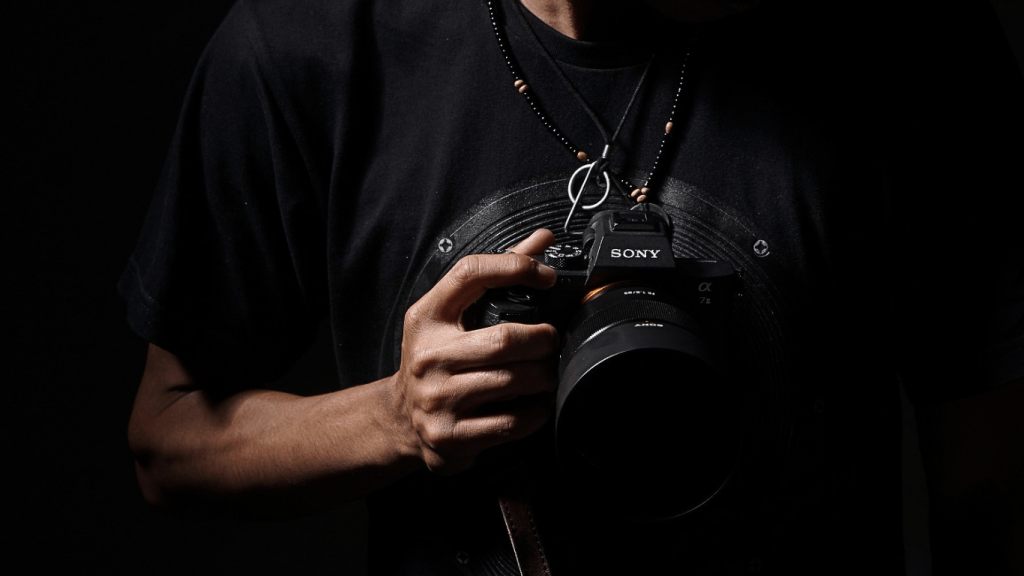 Foto pria memegang sony a7iv, menjadi salah satu kamera mirrorrles untuk pemula di 2026